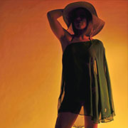 Orange background, with a darkened female model in a dress and large hat.