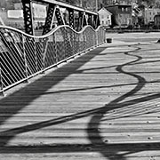 Black and white photo of a bridge with shadows on it.